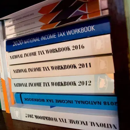 a stack of tax books on a shelf