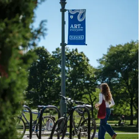 A student walks in front of a bike rack and light pole.