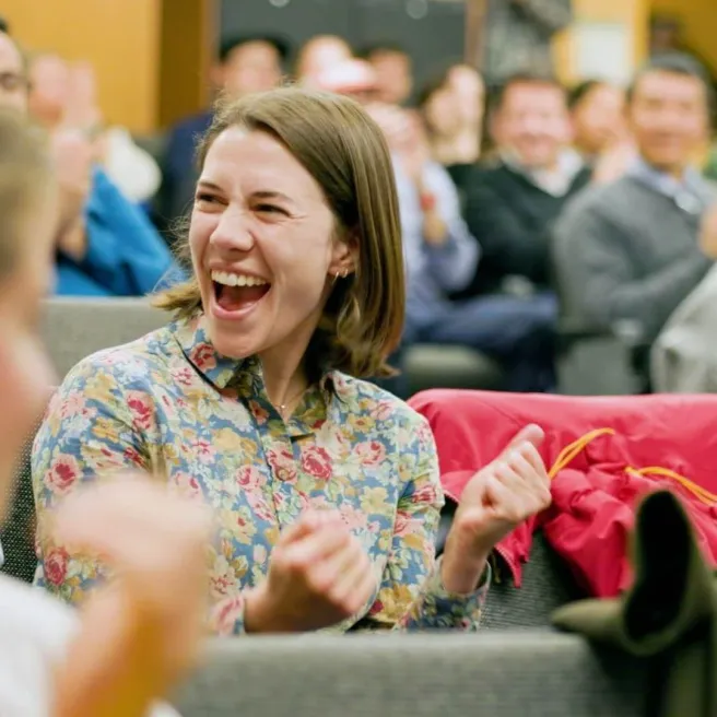 Anna Massell - RSENR PhD student celebrating in a lecture hall with people around her