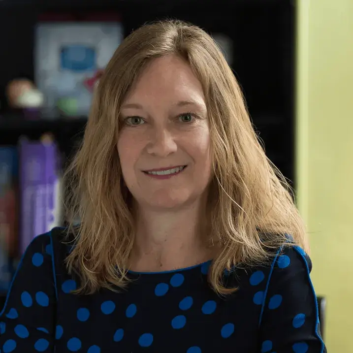 Kelly, smiling for the camera, in an office type setting
