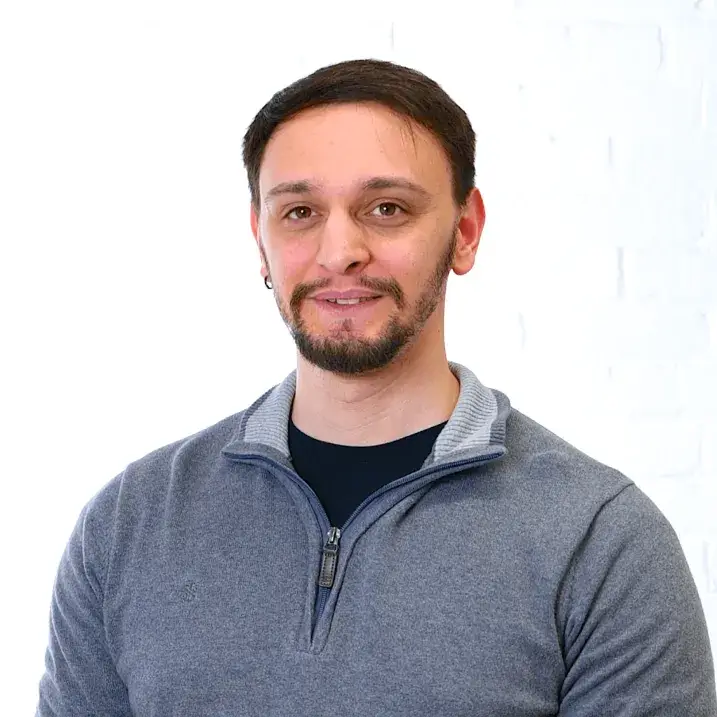 Man in a grey shirt on a white wall