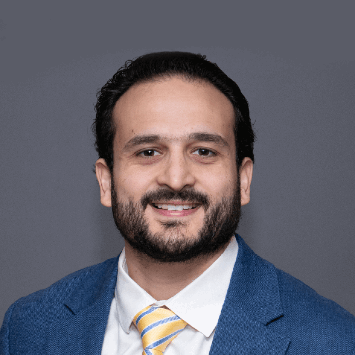 Researcher smiling posed against a grey background