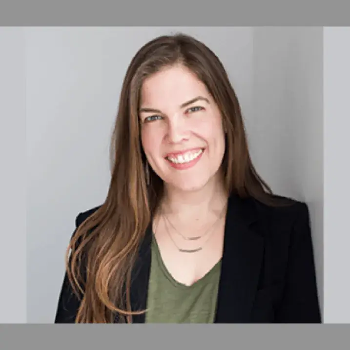 A person wearing a green shirt and black blazer