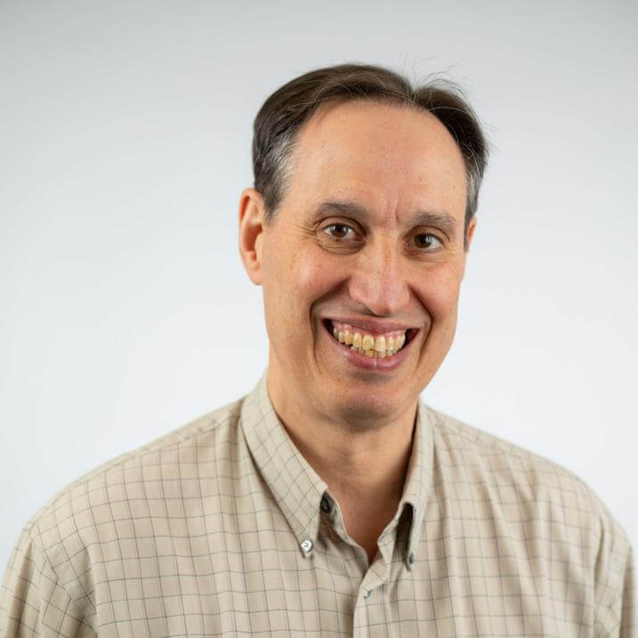 A person wearing a light tan plaid shirt