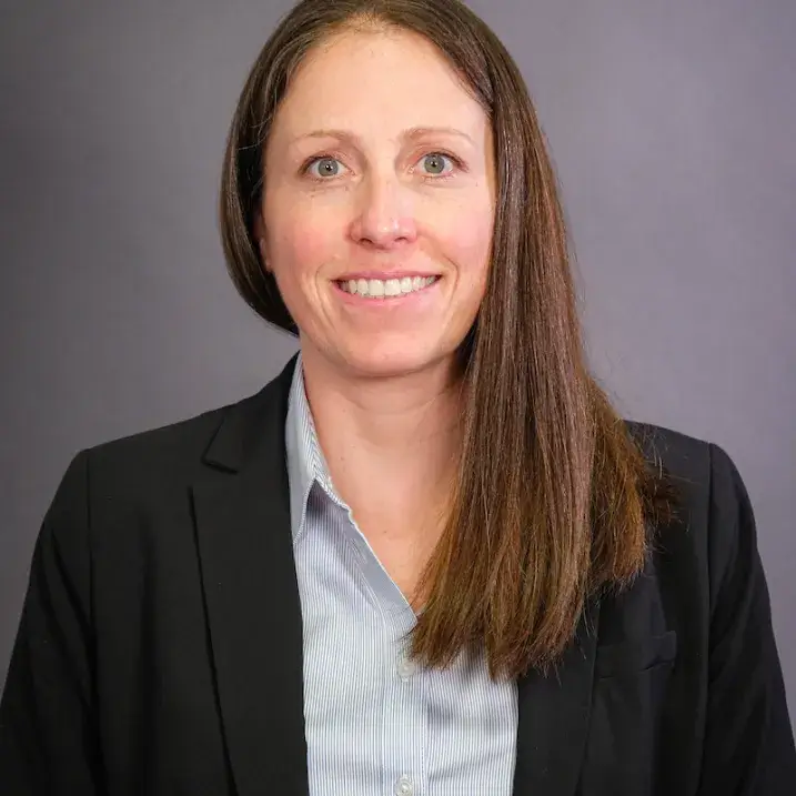 A person wearing  a blue shirt and a black blazer