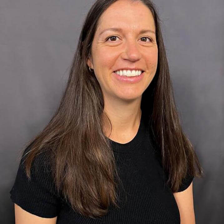 A person with long brown hair wearing a black t shirt