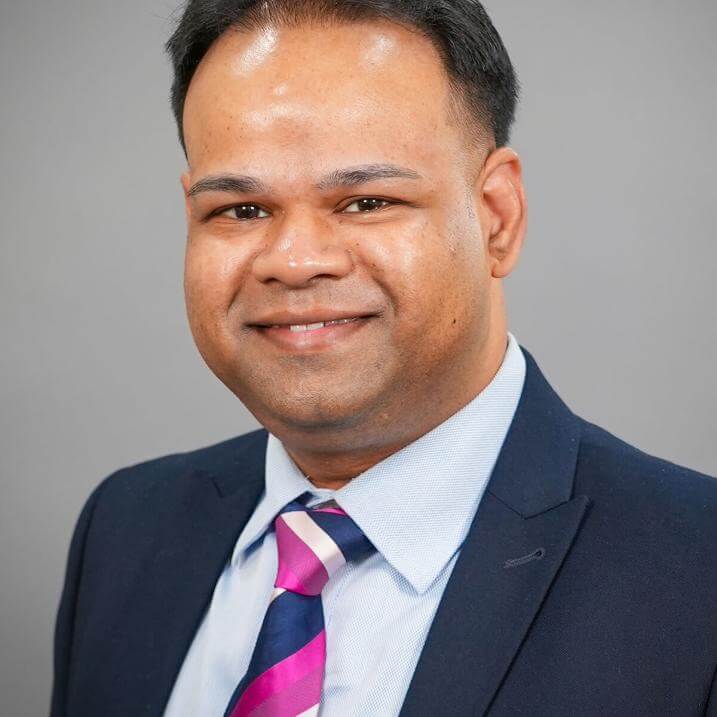 A person wearing a blazer and a purple striped tie