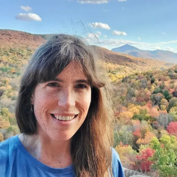 Sophie in front of a sweeping mountain view in autumn colors