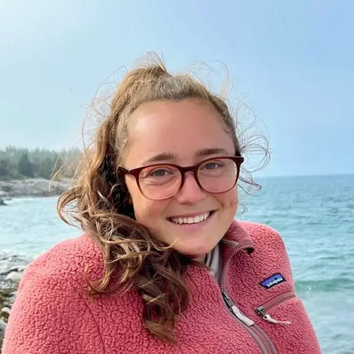 Zoe in front of a rocky shore