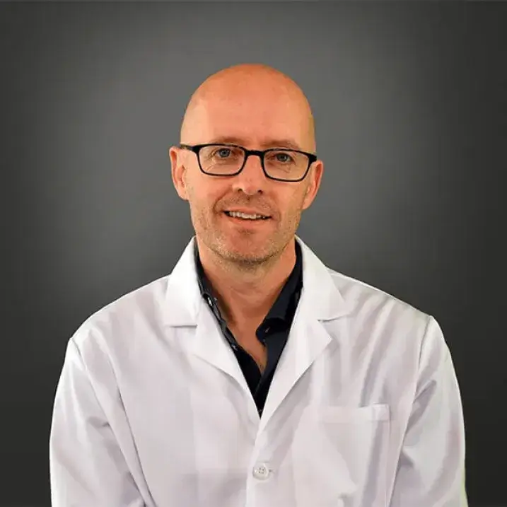 man in white coat wearing glasses