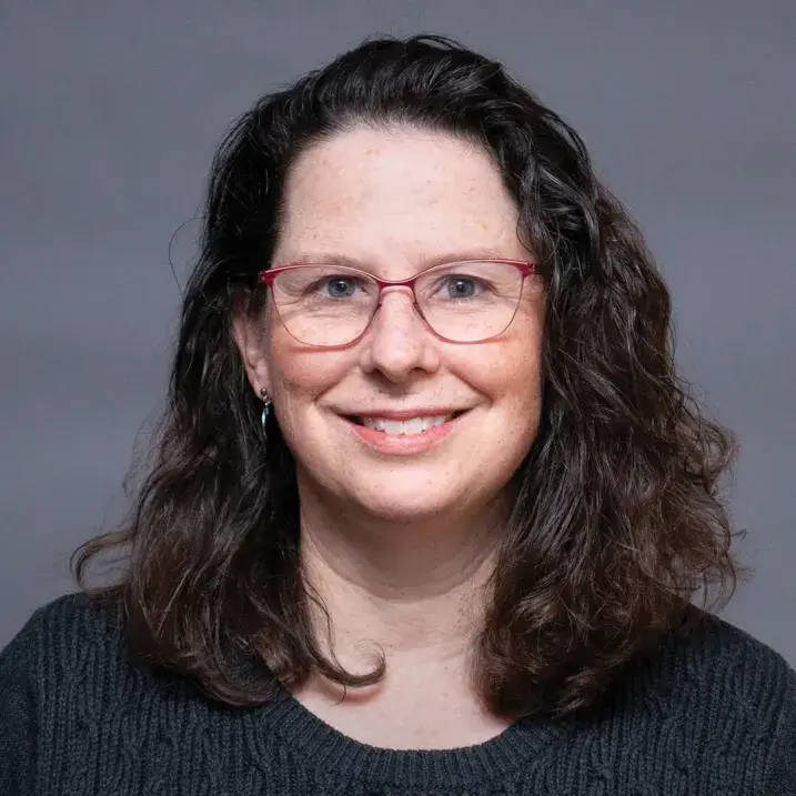 portrait of person wearing glasses, long hair and a black shirt