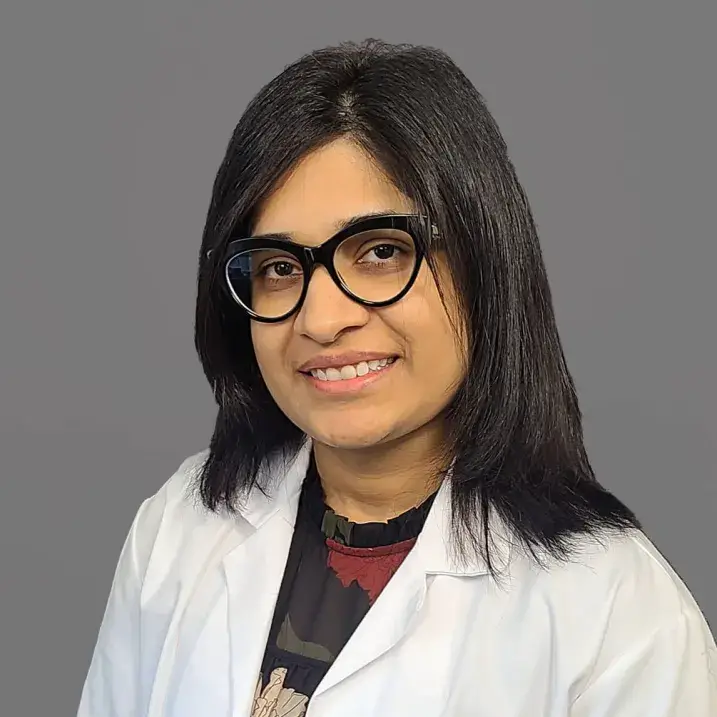 woman with long black hair wearing a doctors coat