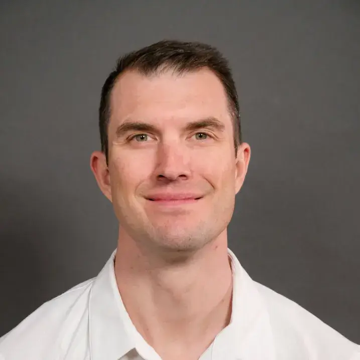 Man in light colored shirt with short dark hair and light skin
