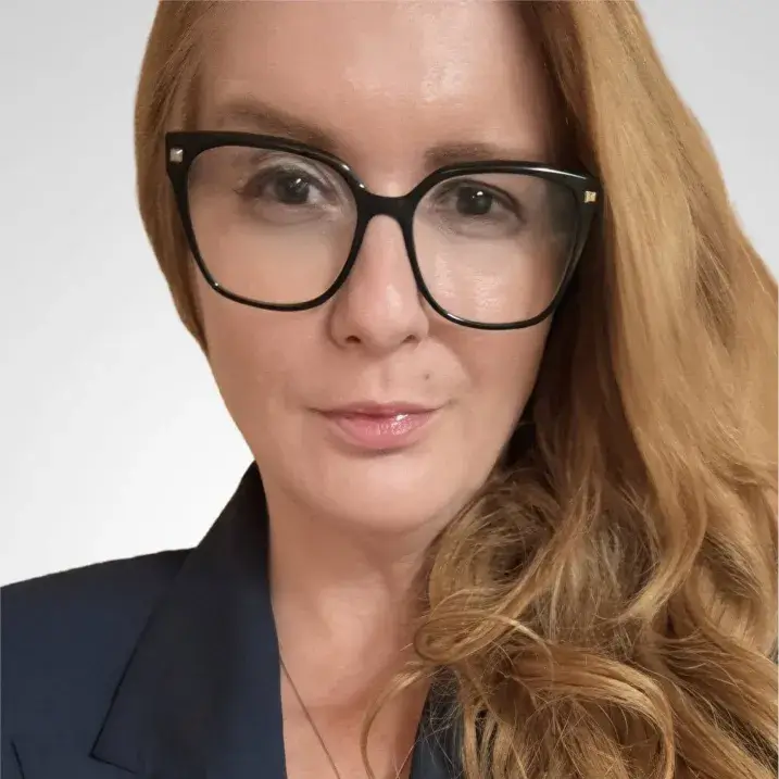 Photo of Alena Demirovic, she is wearing glasses, she has red hair.