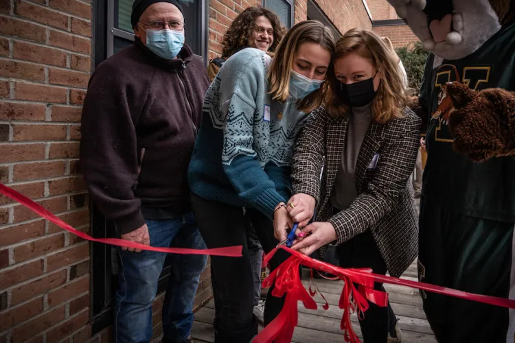 people cutting the ribbon outside of Rally Cat's Cupboard