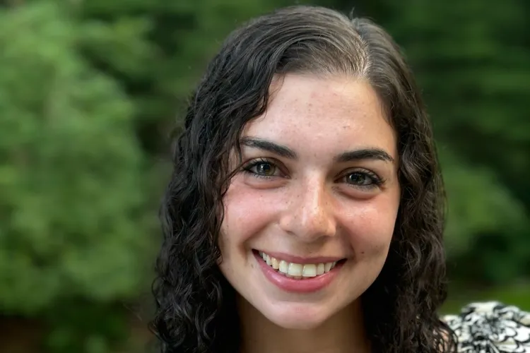 close-up of smiling young woman with long, curly brown hair