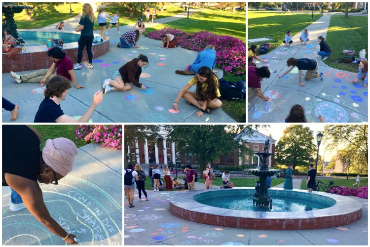 Students in Kelly Becker's class creating art on campus near the fountain on the UVM Green