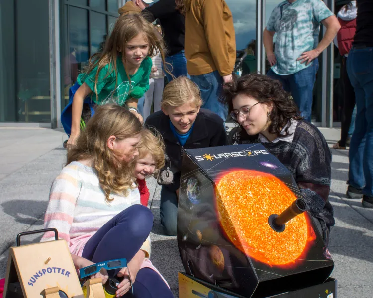 UVM SPS member Sarah Phillips helping visitors safely see a solar eclipse
