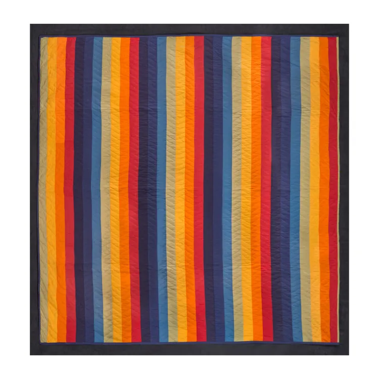 Bright vertical stripes of red-oranges and blues dominate this quilt.