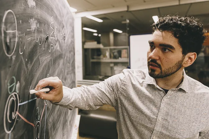 Tobias Timofeyev writing on a chalkboard