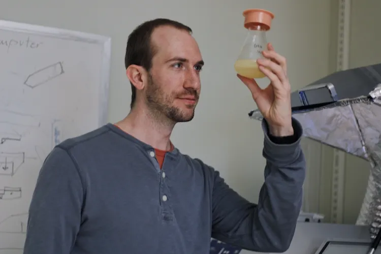 student looking at a science beaker filled with fliud