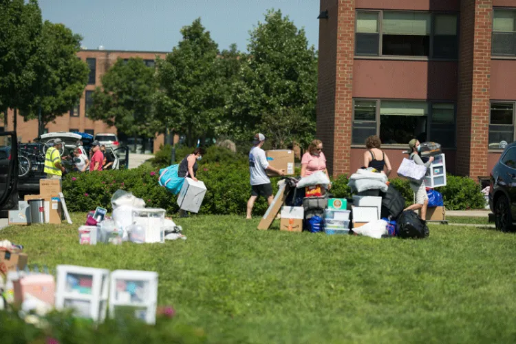 Students and families unload their cars and pile their belongings outside residence halls