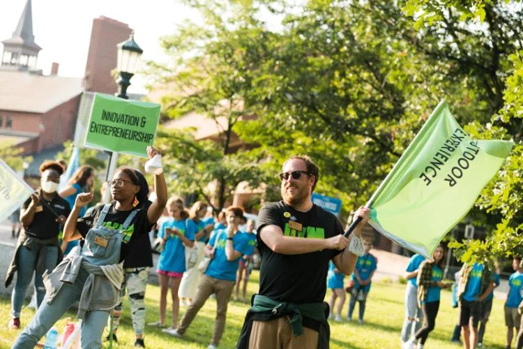 Student leaders wave flags for the Outdoor Experience and Innovation and Entrepreneurship Learning Communities
