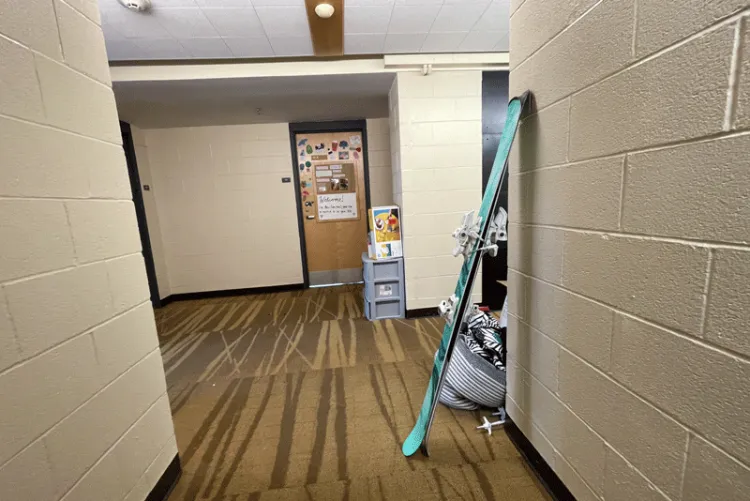 A pair of skis lean against a wall in a hallway of Davis Hall