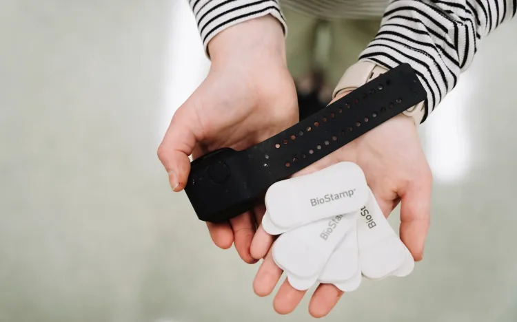 Bryn Loftness holds sensory devices that detect motion and are placed on kids to try and determine a digital fingerprint for anxiety disorders