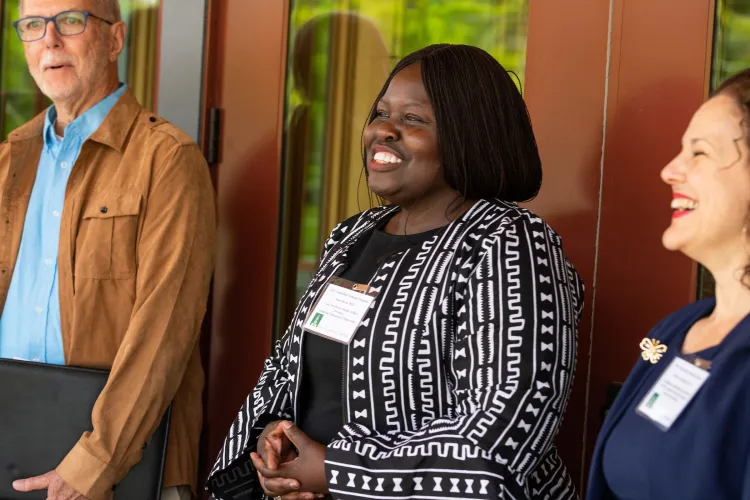 Jane Okech smiles in a crowd outside the UVM alumni house