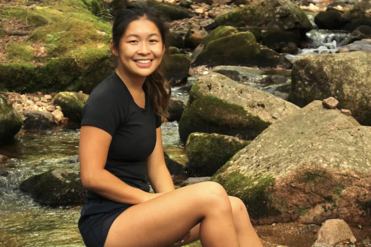 Ella Kenney sitting by a stream.