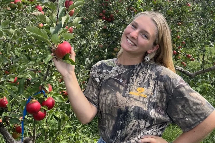 Lila Krugman picking an apple