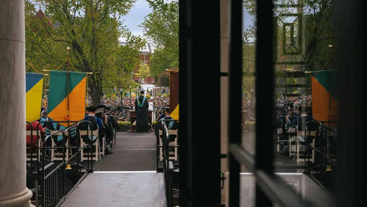 extensive commencement crowd shown through a doorway