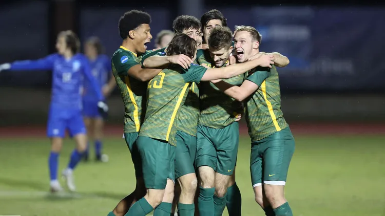 The UVM men's soccer team celebrates a win 