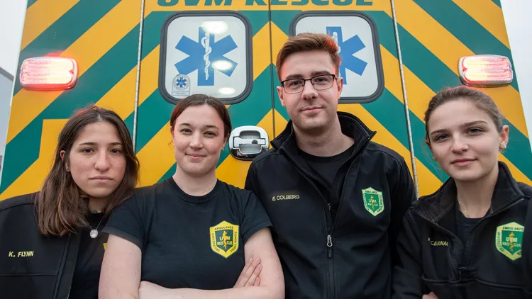 Members of UVM Rescue pose in front of an ambulance