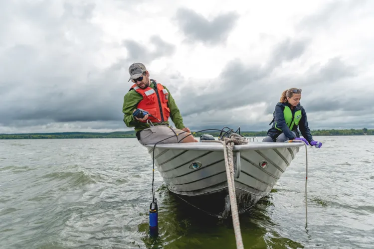 Research technician Saul Blocher and PhD student Katelynn Warner on a rowboat in Lake Champlain.