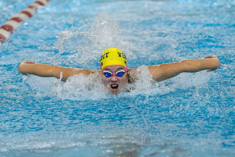 A student mid-stroke in the water
