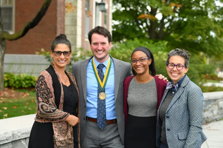 HESA faculty members with a student in front of Waterman Building.