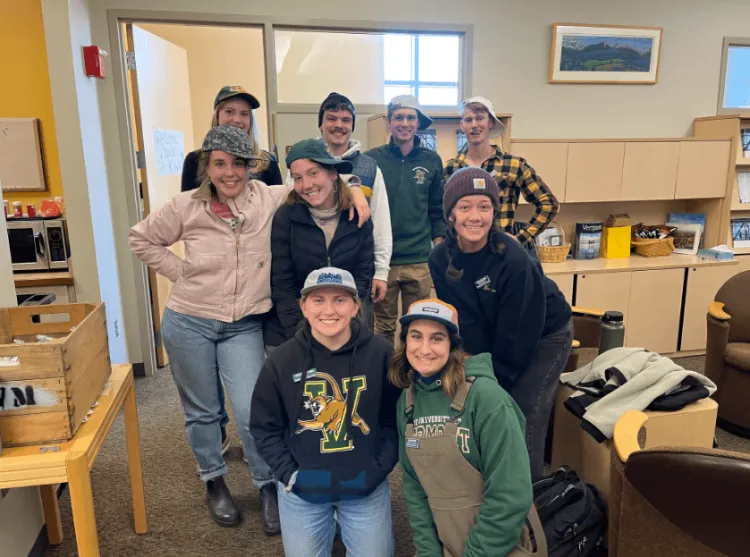 A smiling group of UVM tour guides pose together