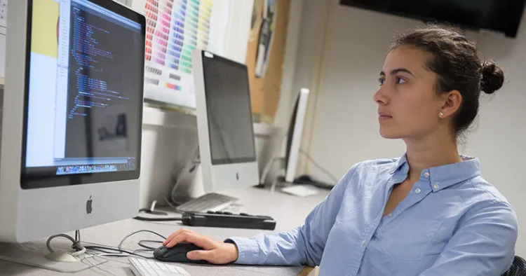 CS student coding on a lab computer