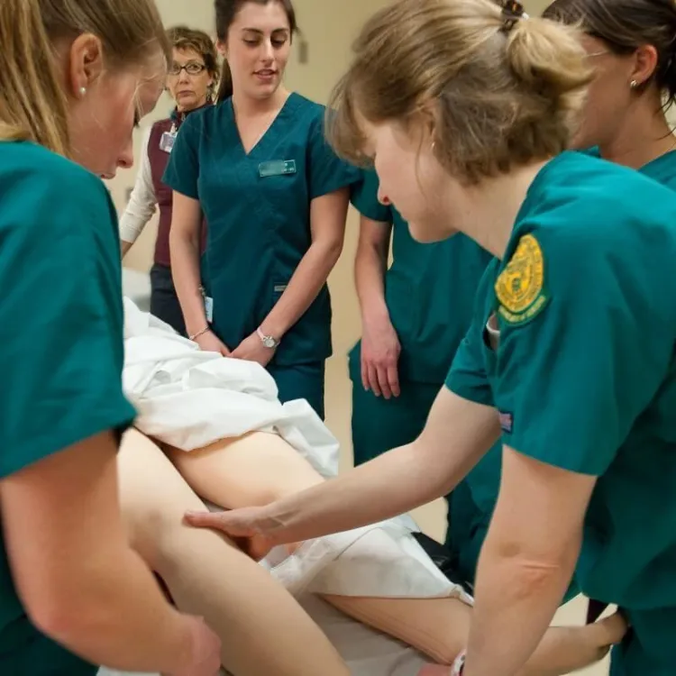 Nursing students practice skills on a mannekin in the simulation lab