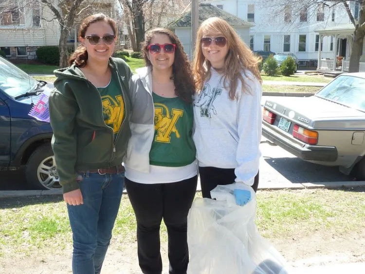 Group of students posing with the trash they collected during a neighborhood clean-up.