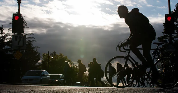 Cyclist and pedestrians at a campus crosswalk