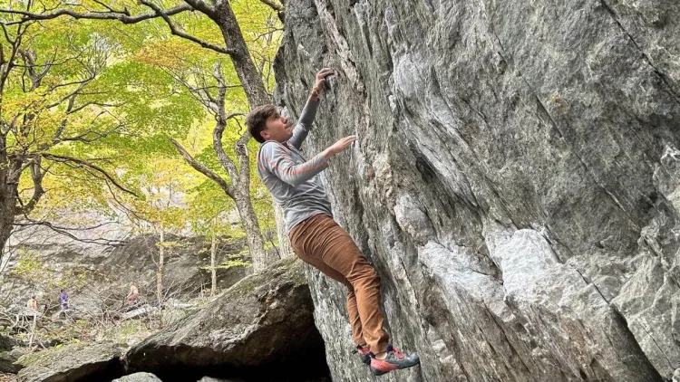 Chris rock climbing in the forest.