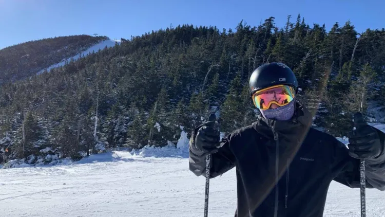 Gus putting two thumbs up while on a ski mountain.