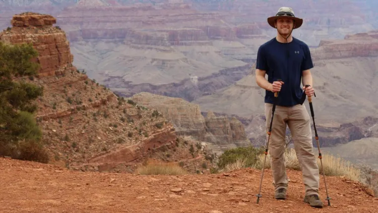 Parker standing in a canyon with hiking poles.