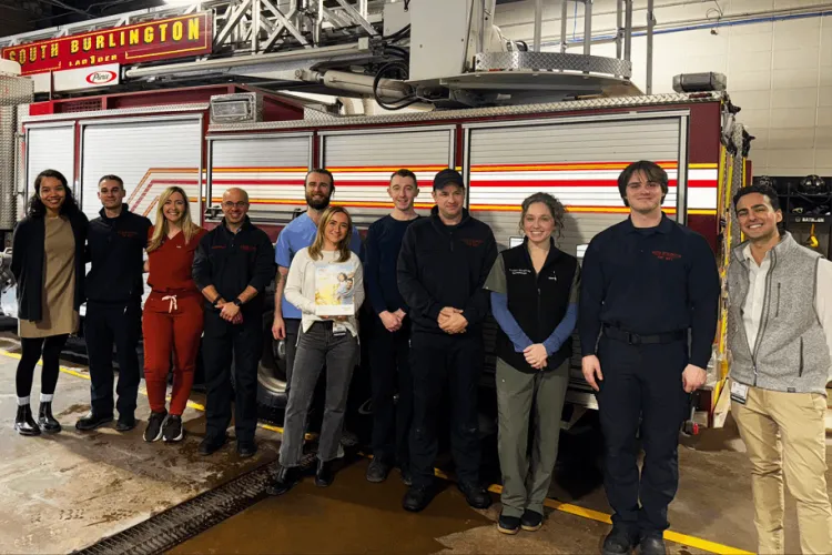 a group of people standing in front of a fire truck in a truck bay
