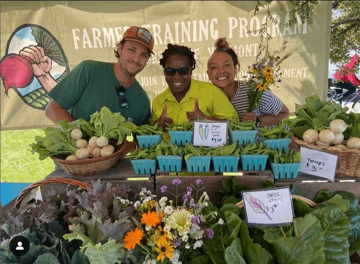 Three Catamount Farmers in training at the farm stand offering produce and flowers