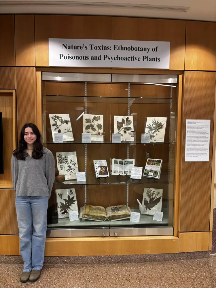 Kylie standing next to display case
