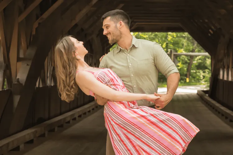 a woman and a man dancing in a covered bridge
